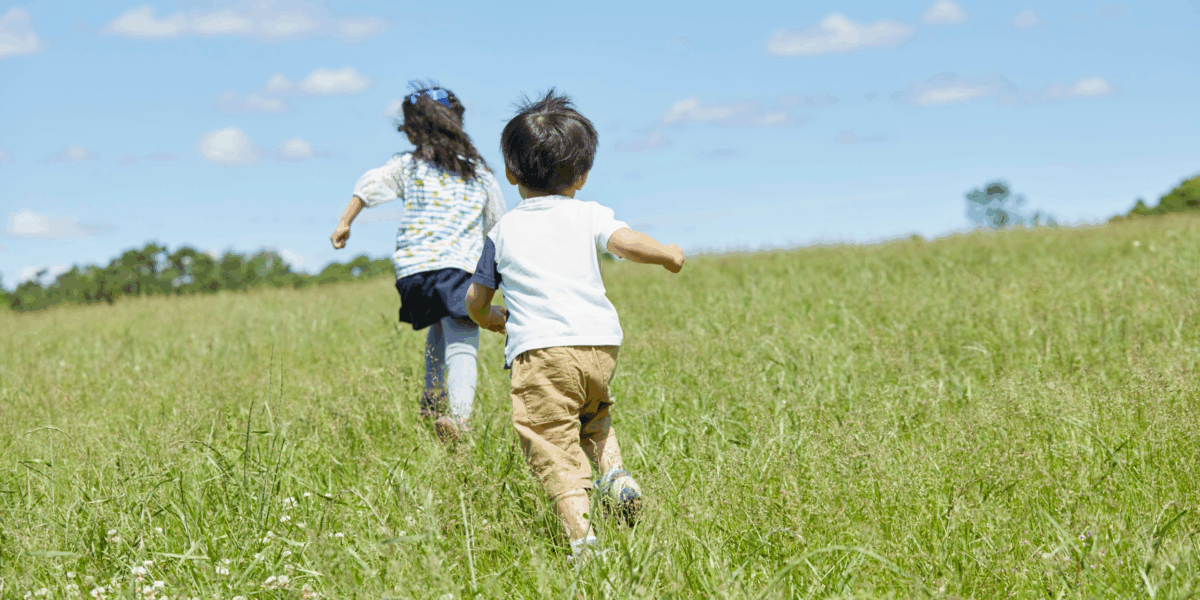 Two children chasing each other and playing outside
