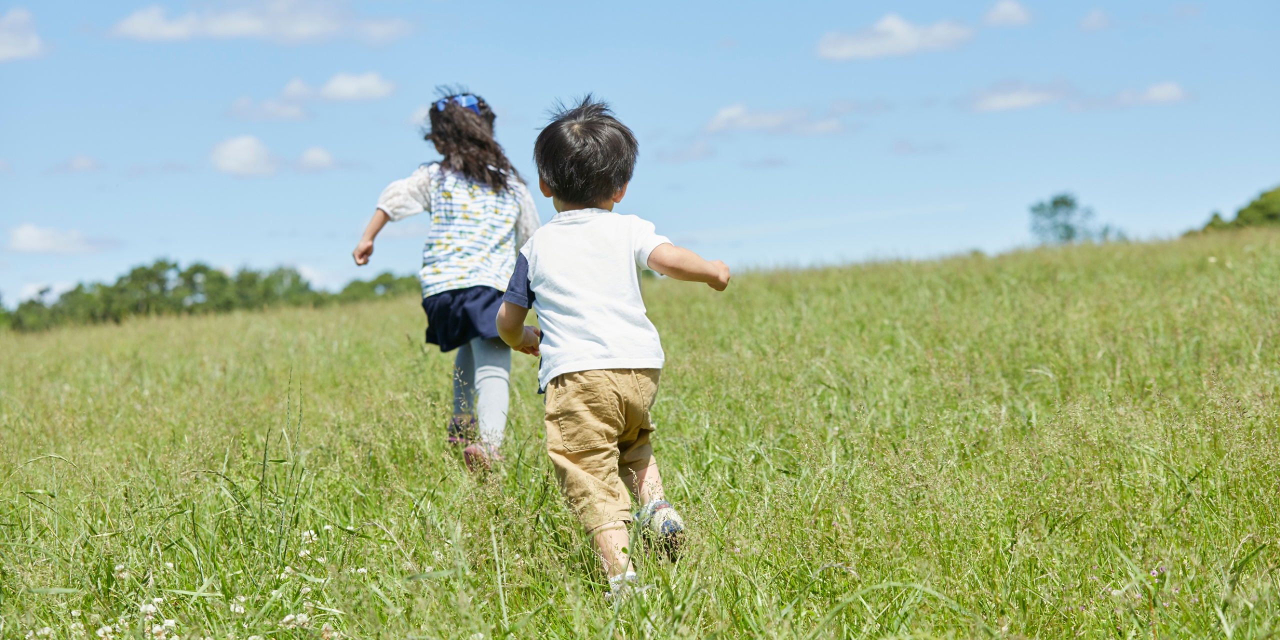 Two children chasing each other and playing outside